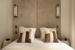 Ein Hotelzimmer mit einem großen Bett, zwei Nachttischen und Wandleuchten.