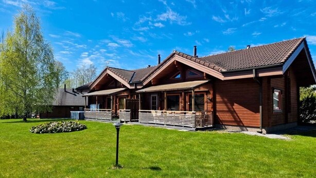 A wooden cabin with a sloped roof, a porch, and a well-maintained lawn. - Villa Persikka, Himoslaakso Ski-in/out (Keski-Suomi)