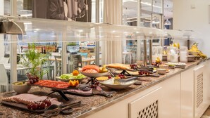 Buffet com diversos alimentos e utensílios.