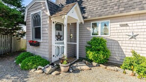 A house with a porch, a window with a star decoration, and a small garden area.