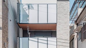 En moderne bygning med flere etager, garageindgang, store vinduer og facade i mursten.
