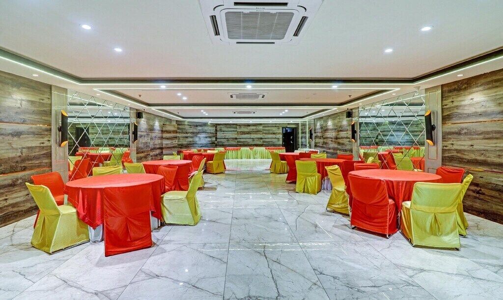 A conference room with multiple tables and chairs, marble flooring, and wooden panel walls.