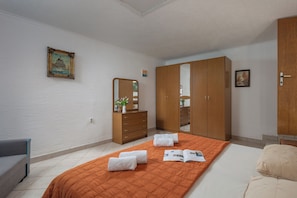 A bedroom with a bed, a dresser, a mirror, and a wardrobe. - Beach House Astrid (Malinska-Dubasnica)