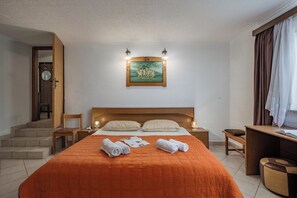 A hotel room with a bed, a desk, a chair, a nightstand, and a painting on the wall. - Beach House Astrid (Malinska-Dubasnica)