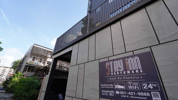 A building with a sign for 'Stay Inn Ha Ykwang' advertising room for rent, free WiFi, and 24-hour availability.