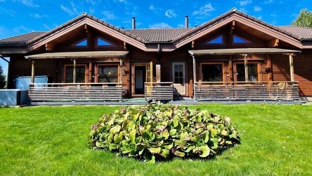 A wooden lodge with a symmetrical facade, large windows, and a central entrance. - Villa Kastanja, Himoslaakso Ski-in/out (Keski-Suomi)
