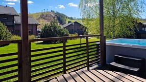 A wooden deck with a pool, overlooking a green landscape and houses. - Villa Kastanja, Himoslaakso Ski-in/out (Keski-Suomi)