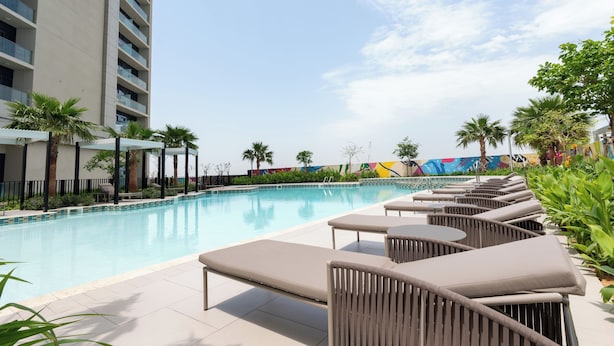 A poolside area with lounge chairs and a swimming pool. - Keyrock Living - Luxury at Aykon Tower (Dubai)