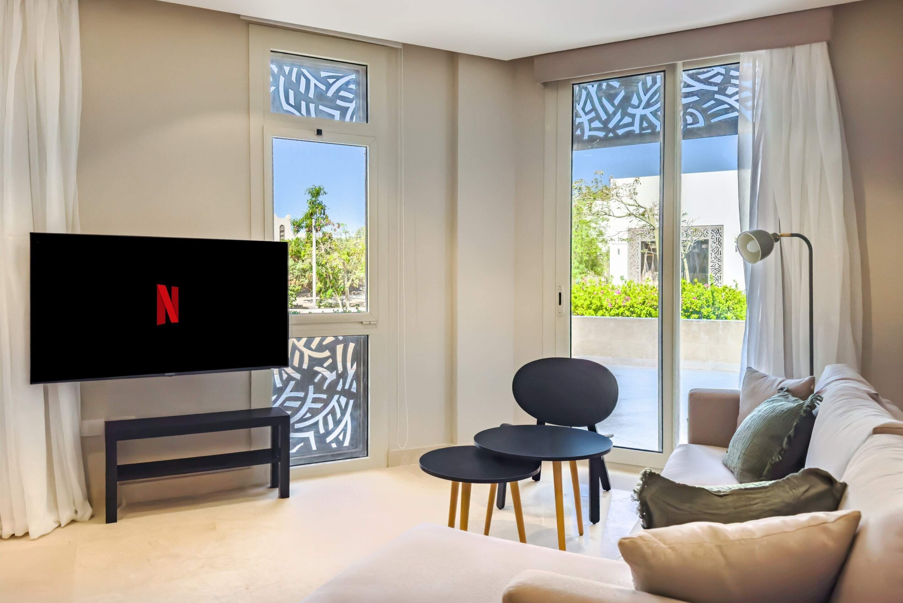 Ein modernes Wohnzimmer mit Flachbildfernseher, einer Couch, einem Couchtisch und einer Bank.