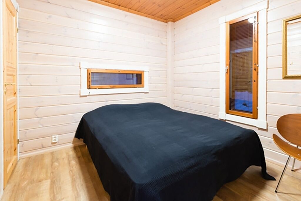 Une petite pièce agréable, avec un lit, une fenêtre et une porte.