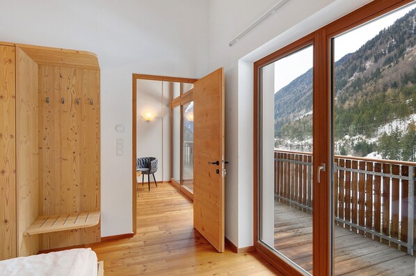A wooden interior with a balcony overlooking a mountainous landscape.