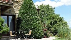 A stone building with a patio, two chairs, and a potted plant. - Villa MOKA Apartment EMMA in an old farm(15th century) in Montefeltro(Le Marche) (Lunano)