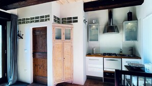 A compact kitchen with wooden cabinets, a stove, and a sink. - Villa MOKA Apartment EMMA in an old farm(15th century) in Montefeltro(Le Marche) (Lunano)