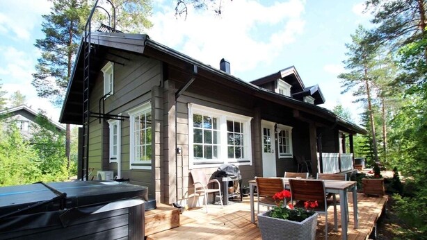 A wooden deck with outdoor furniture, a hot tub, and a patio area with potted plants. - Villa Slalom 2, Himos Länsihuippu (Keski-Suomi)
