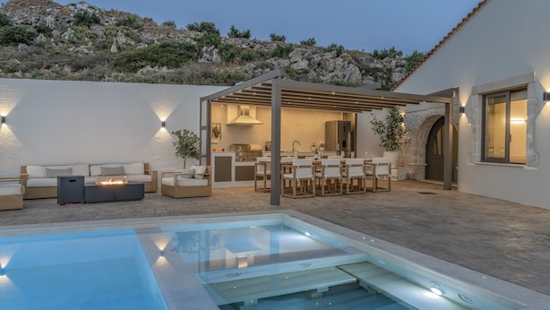 Un espace piscine extérieur moderne, doté d’un jacuzzi, de sièges et d’un patio couvert.