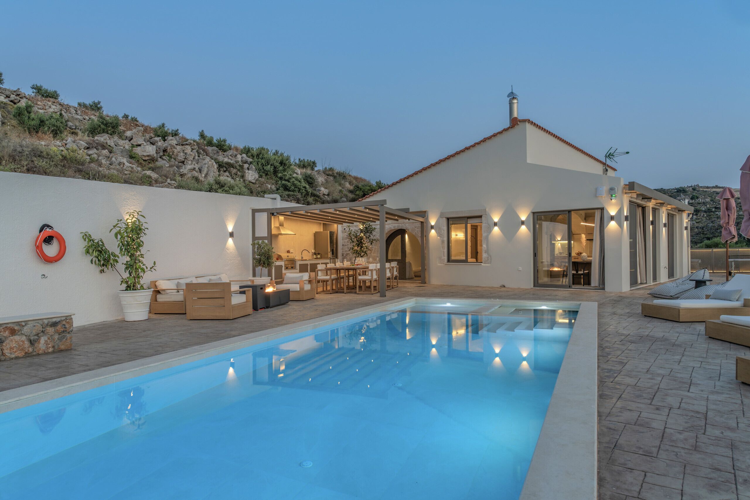 Uma casa moderna com piscina, área de estar externa e um alpendre.