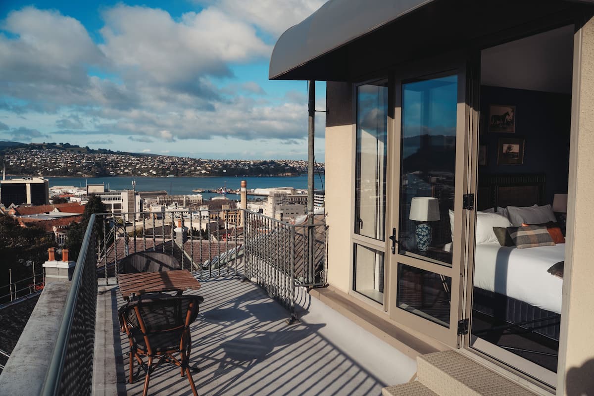 Ein Balkon mit Blick auf eine Stadtlandschaft und Wasser.