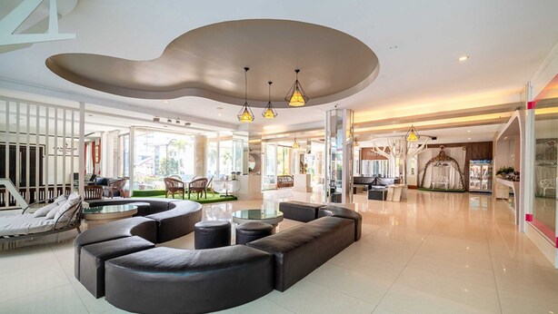 A spacious lobby with a curved seating area, a reception desk, and a view of the outside.
