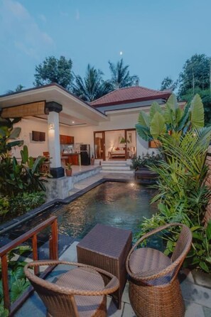 A modern house with a swimming pool, wicker furniture, and lush greenery. - Tegal Harum Villas (Ubud)
