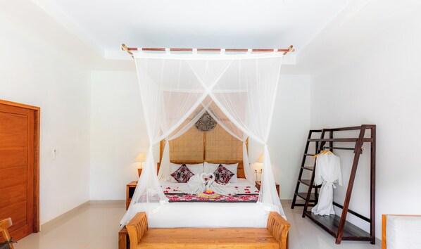 A room with a four-poster bed, a wooden bench, a ladder, and a wardrobe. - Tegal Harum Villas (Ubud)