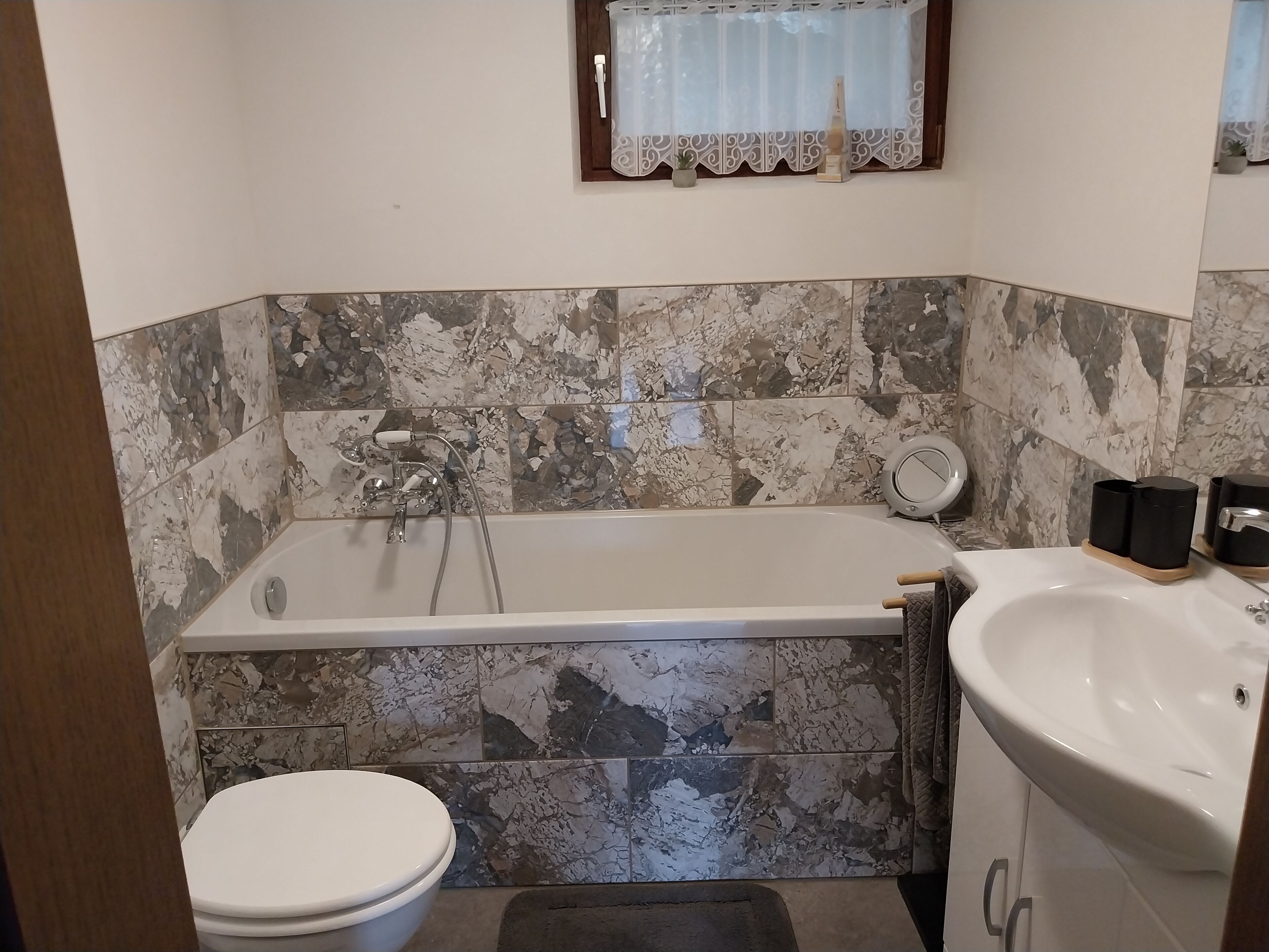 A bathroom with a bathtub, toilet, and sink.