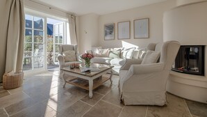 A living room with a sofa, armchairs, a coffee table, and a fireplace. - Finn's Hüs - A Stylish Thatched-Roof House in Wenningstedt on Sylt (Wenningstedt-Braderup (Sylt))