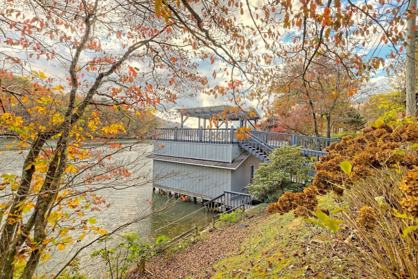 A riverside walkway with a wooden bridge and a gazebo.