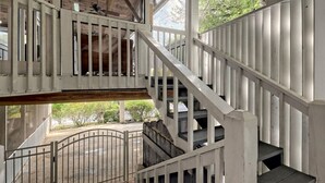 A wooden staircase with white railings leading to an upper level.
