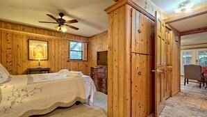 A bedroom with a bed, a dresser, a wardrobe, a ceiling fan, and a window. - Lake Burton Bungalow with Top Dock & Scenic Patio (Clayton)