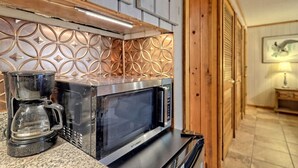A kitchen with a coffee maker and microwave on a granite countertop. - Lake Burton Bungalow with Top Dock & Scenic Patio (Clayton)