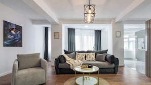 A modern living room with a sofa, armchair, and coffee table. - Pop-up Aparthotel (Bucharest)