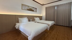 A hotel room with two beds, a large window with curtains, and a painting on the wall. - PALA Garden Hotel (Vientiane)