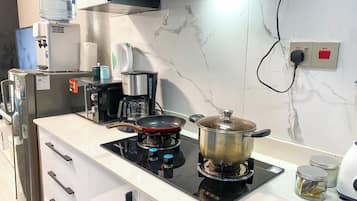 Deluxe studio | Privékeuken | Een magnetron, kookgerei, borden en bestek