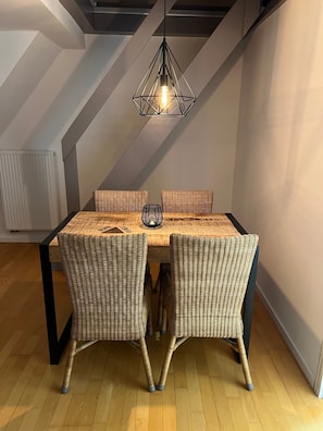 Un comedor con mesa, sillas y una lámpara colgante.