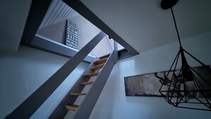A staircase with wooden steps, a wall-mounted light fixture, and a framed quote on the wall. - Saarner Loft Apartment with Private Terrace, Garden, and Wi-Fi (Mülheim an der Ruhr)