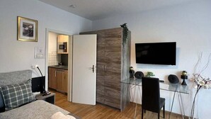A modern bedroom with a bed, bedside table, and a TV mounted on the wall. - Riverside Retreat in Koblenz (Koblenz)