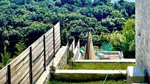 A patio with a view of a lush landscape and distant mountains.