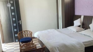 Una habitación de hotel con una cama, una silla, un televisor y una puerta con un número.