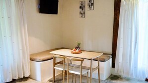 A small, cozy room with a wooden table and two chairs, a bench, and a television mounted on the wall. - 2-Mezzanine bedroom villa in Bali (Bali)