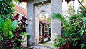 A traditional Balinese house with a thatched roof, a central courtyard, and lush tropical vegetation. - 2-Mezzanine bedroom villa in Bali (Bali)