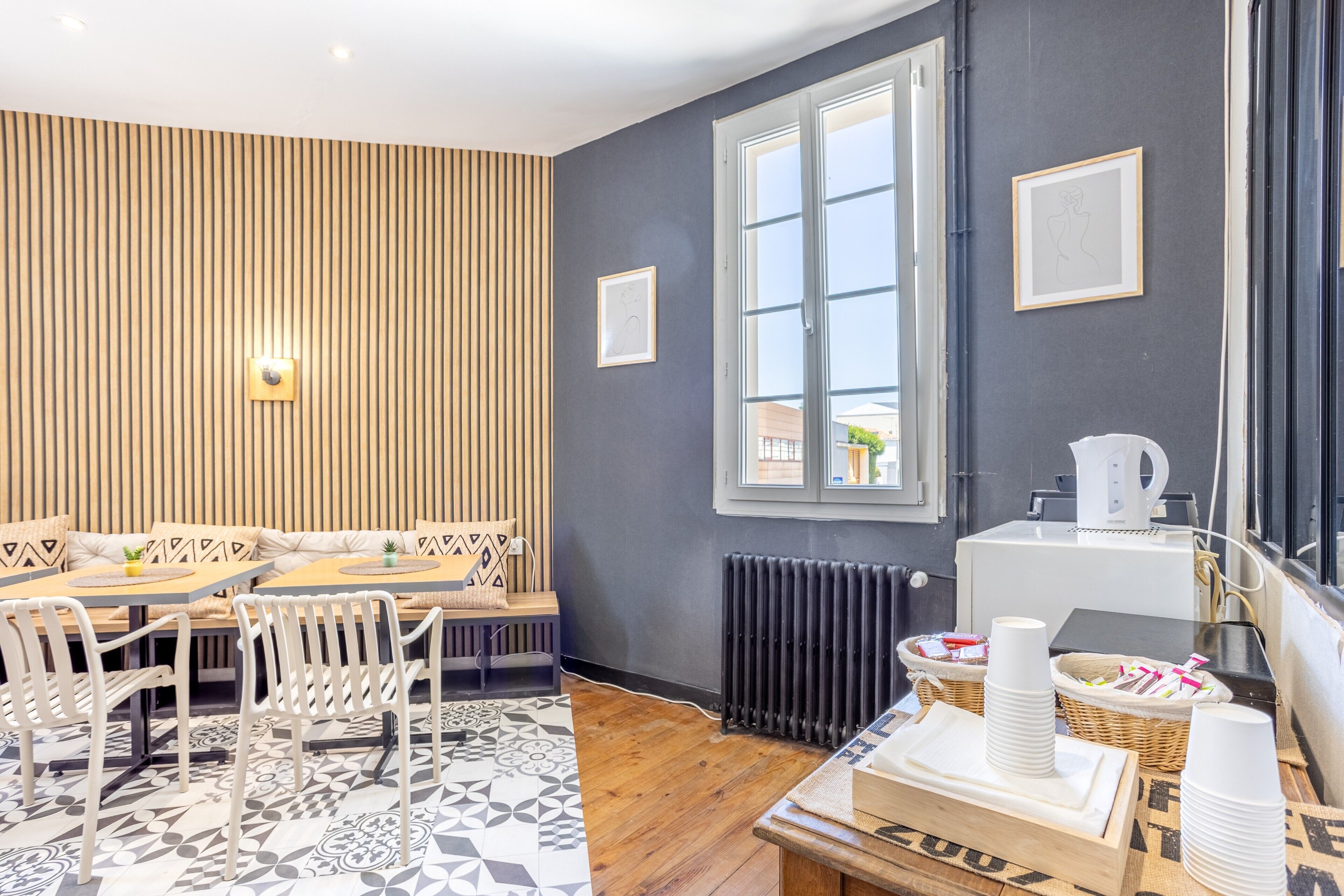 Een moderne kamer met een eethoek, een radiator en een raam.