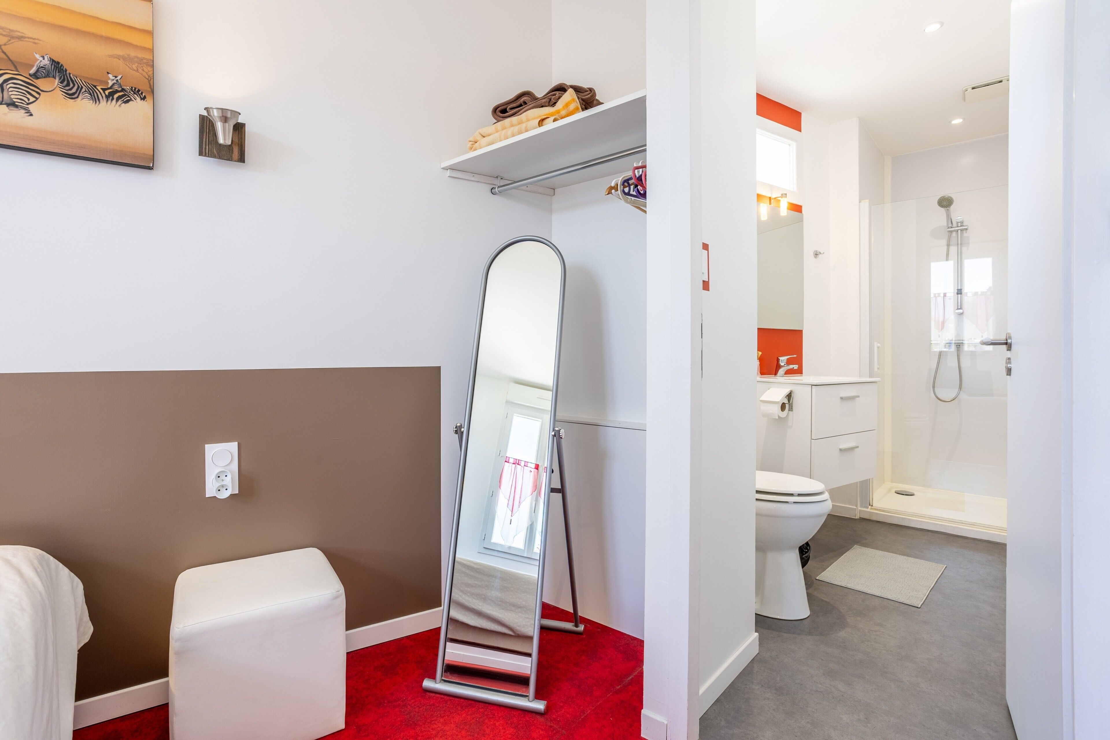 Une salle de bain avec une douche, des toilettes et un miroir.