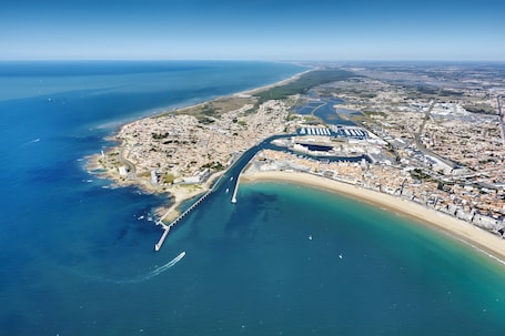 An aerial view of a coastal city with a prominent marina, a long pier, and a beach.. Room 'N°01' with Wi-Fi