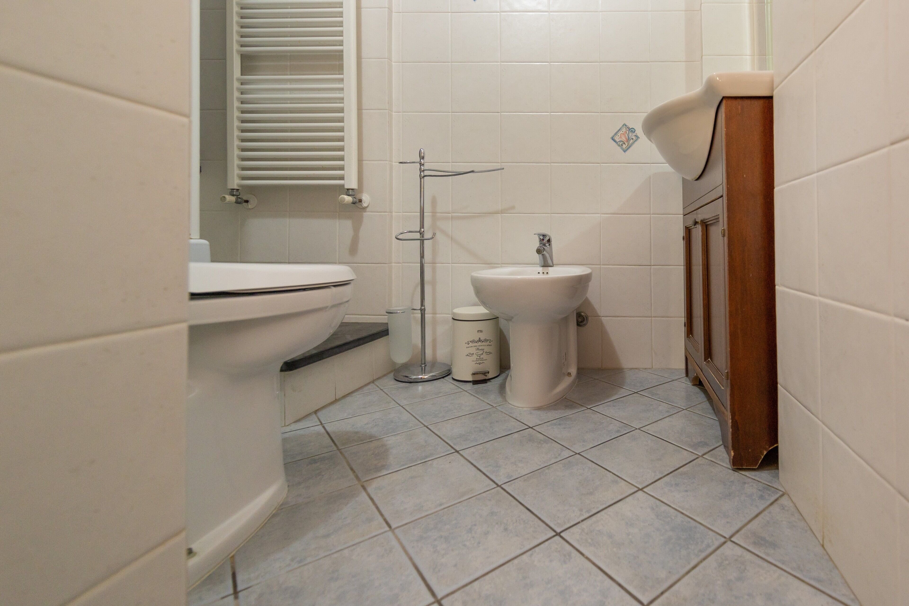 A bathroom with a toilet, bidet, and sink.