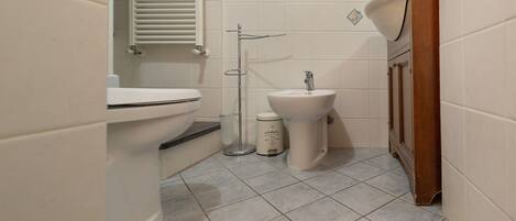 A bathroom with a toilet, bidet, and sink.