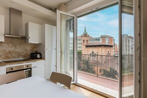 A modern kitchen with a large sliding glass door leading to a balcony with a city view. - Bologna City Center View by Wonderful Italy (Bologna)