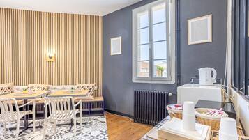 Et moderne værelse med spiseplads, en radiator og et vindue.