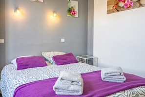 Ein Hotelzimmer mit einem Bett, zwei Kissen, einem Nachttisch und einer Wandleuchte.
