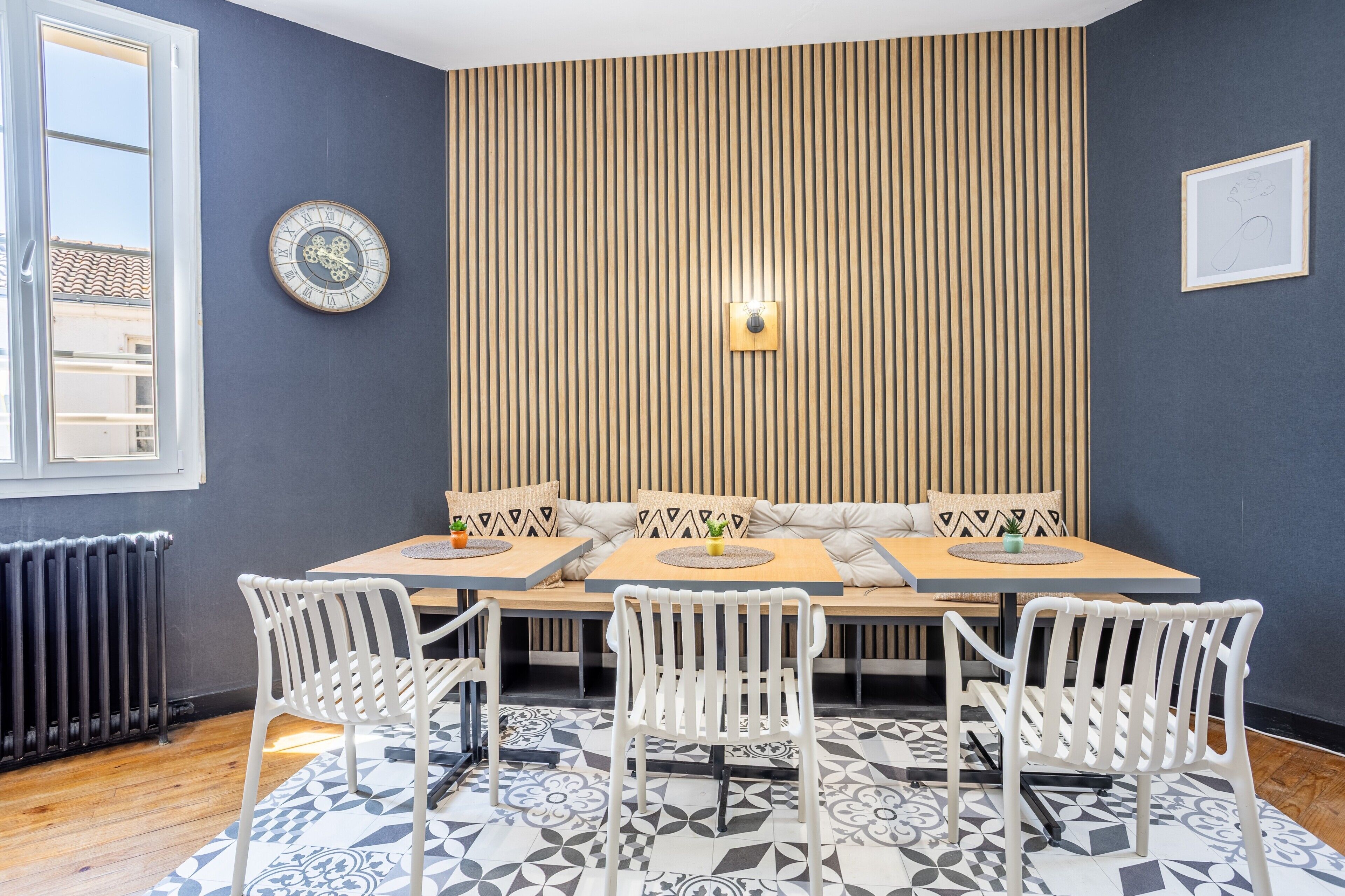 A room with a wooden bench seating, a clock, and a radiator.