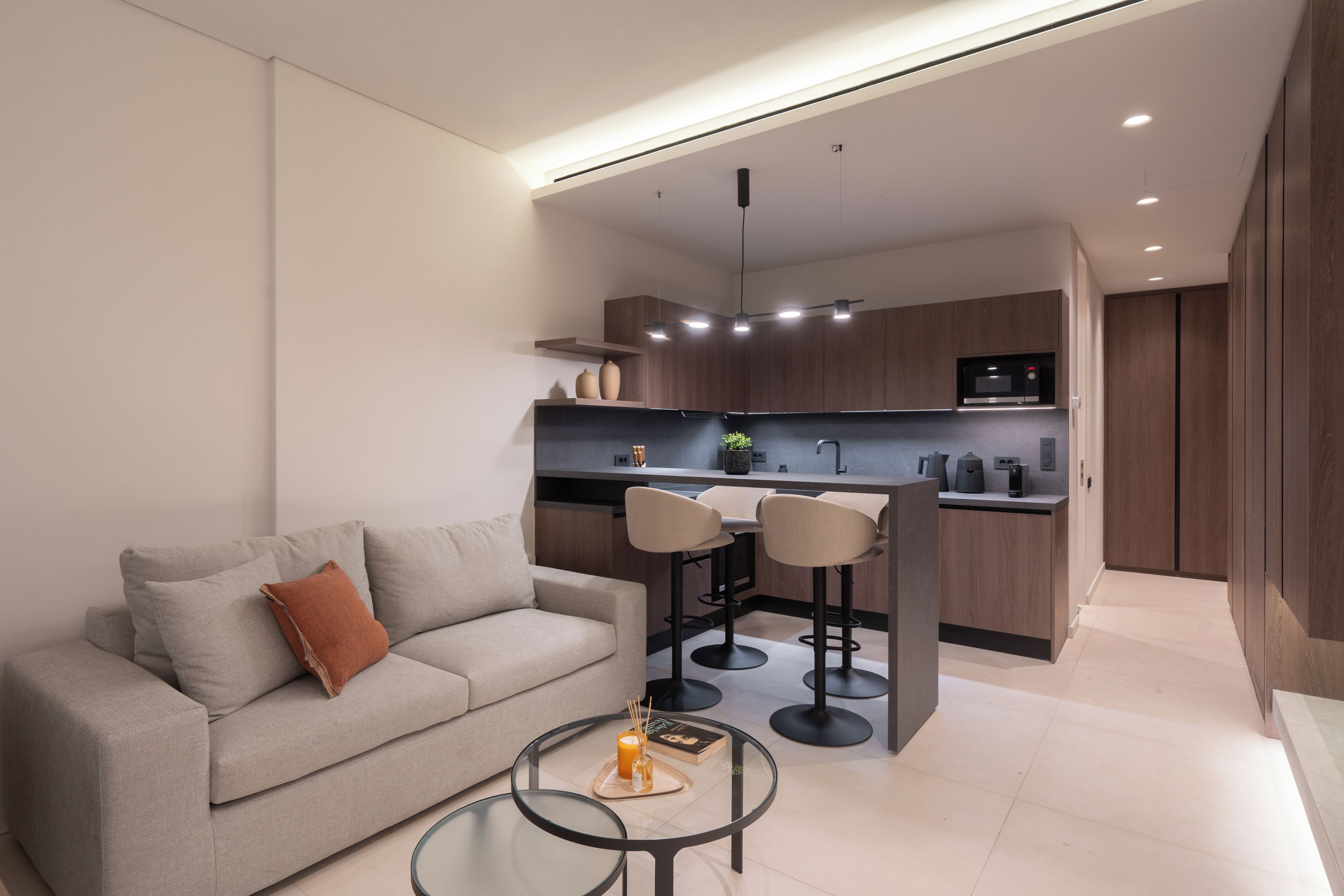 A modern kitchen with a dining area, a sofa, and a coffee table.